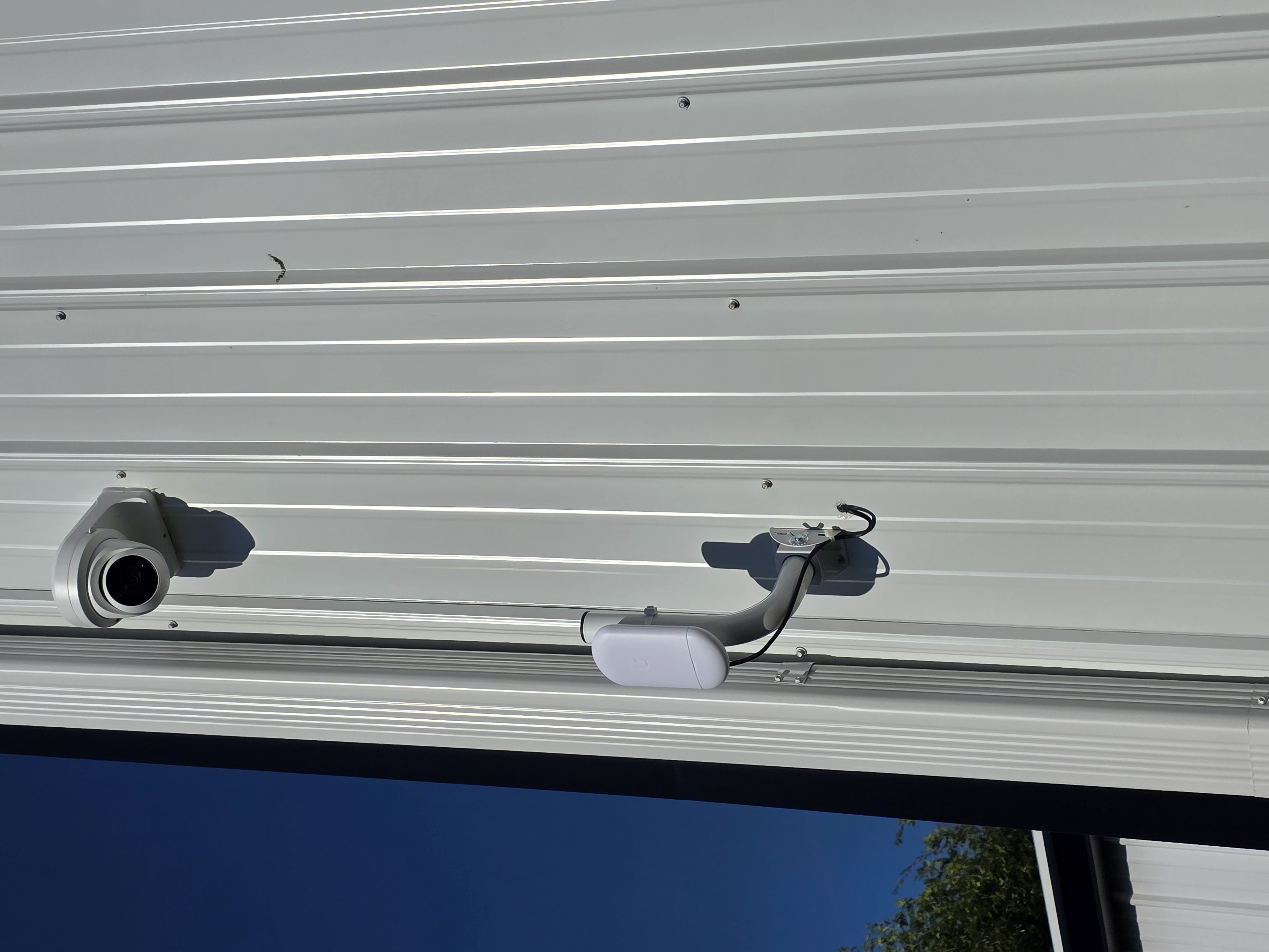 Security camera and wireless bridge mounted on commercial building exterior